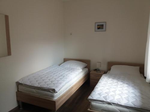 two twin beds in a room with white walls at Störti 11 in Gnies