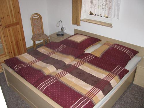 a bedroom with two beds with a chair and a window at Ferienwohnung Anjadina in Storkow