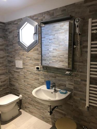 a bathroom with a sink and a toilet and a window at Hotel Delle Rose in Mestre