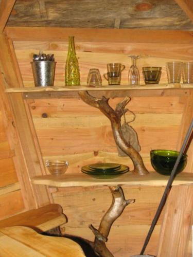 une étagère dans une cabane en bois avec un arbre dans l'établissement Une Nuit aux Lierres..., à Vouzon