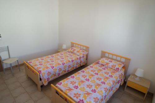 トッレ・サン・ジョヴァンニ・ウジェントにあるAppartamenti a 50 mt dal mareのベッド2台が隣同士に設置された部屋です。