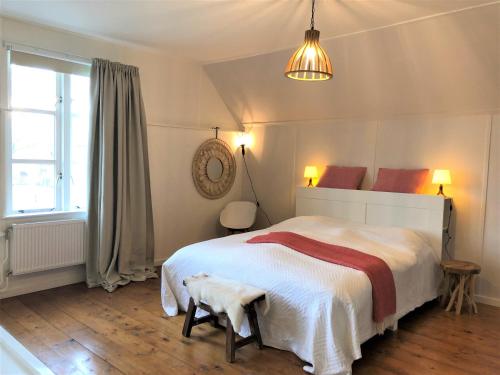 een slaapkamer met een groot wit bed en een raam bij B&NB The Barnhouse in Bergambacht