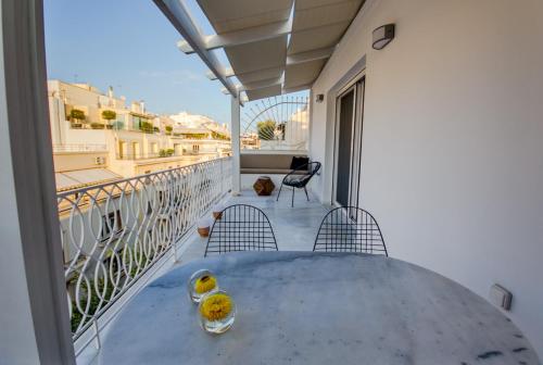 een balkon met een tafel en stoelen bij Bluscapes Home in Athene