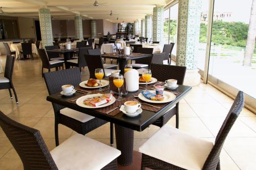 un ristorante con tavoli e sedie con cibo sopra di Hotel Il Gabbiano a Bacoli