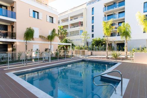 une piscine devant un immeuble dans l'établissement 2-Br with Garden and Pool in the Heart of Palm Beach, à Cannes