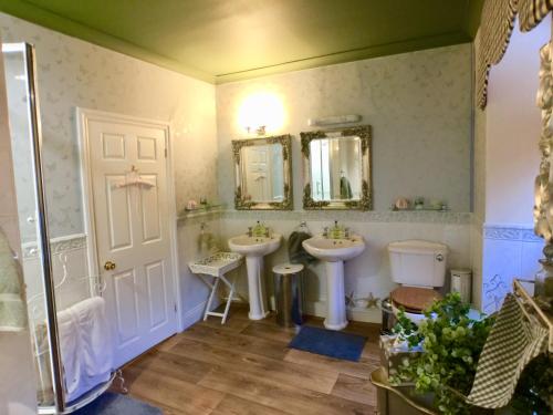 a bathroom with two sinks and two mirrors at The Suites At Ty Anne in Beaumaris