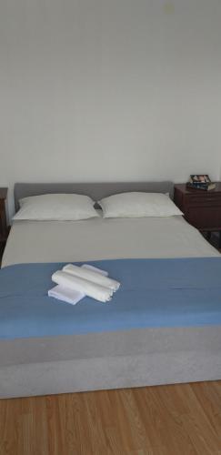 een bed met twee stapels handdoeken erop bij Apartment Sunrise in Stomorska