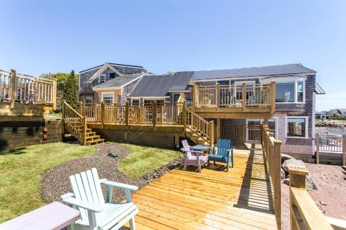 a large deck with two chairs and a house at Seaside Beach Resort in Saint Andrews