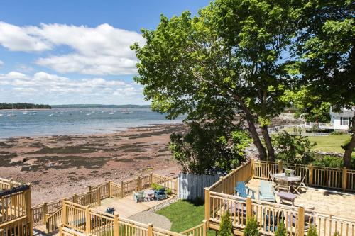 a deck with chairs and a table on the beach at Seaside Beach Resort in Saint Andrews