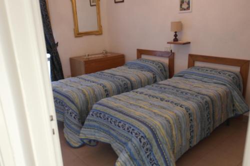 ラポラーノ・テルメにあるCasetta delle Termeの青いシーツが備わる客室のベッド2台