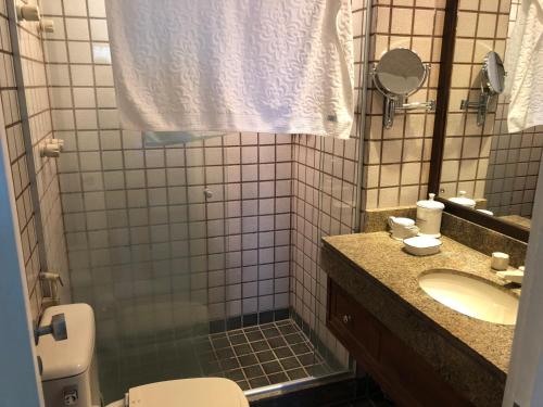 ein Badezimmer mit einem WC, einem Waschbecken und einem Spiegel in der Unterkunft Apartamento no Porto Real Resort com vista para o mar in Mangaratiba