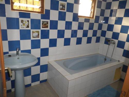 La salle de bains bleue et blanche est pourvue d'une baignoire et d'un lavabo. dans l'établissement Villa la Linguère, à La Somone