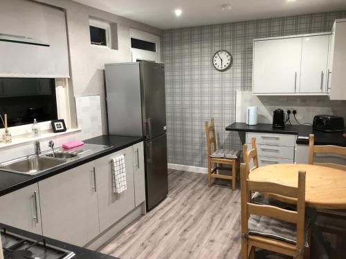 a kitchen with a table and a refrigerator at Old Police House Causewayhead Stirling in Stirling