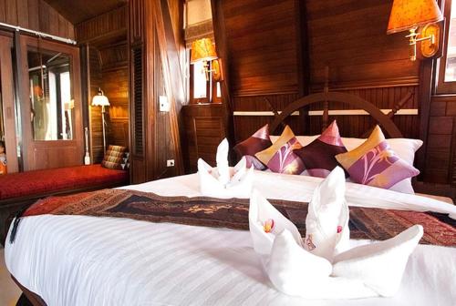 two swans are sitting on a bed in a room at Rin Beach Resort in Haad Rin