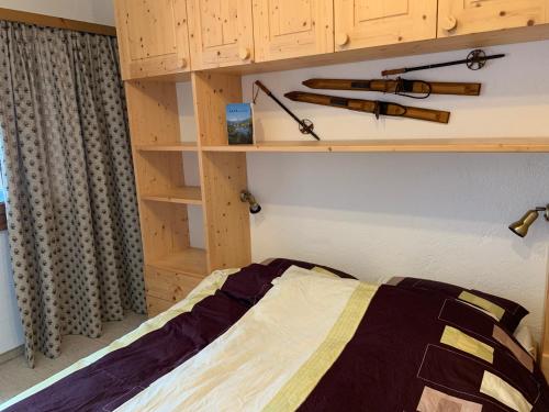 1 dormitorio con cama y estanterías de madera en Ferienwohnung Laax mit Traumblick, großem Balkon und Terrasse, en Laax