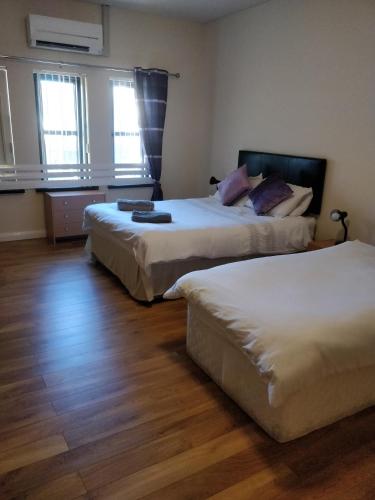 a bedroom with two beds and a desk at The Oldtown Inn in Cookstown