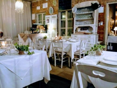 un comedor con mesas blancas y sillas blancas en La Culla di Bacco, en Castagnole Monferrato