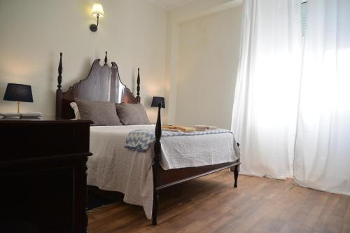 a bedroom with a bed with a wooden headboard at Casa azul in Gouveia