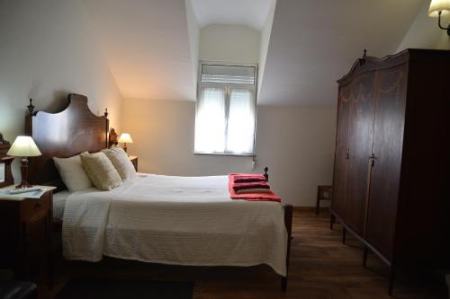 a bedroom with a large bed and a window at Casa azul in Gouveia