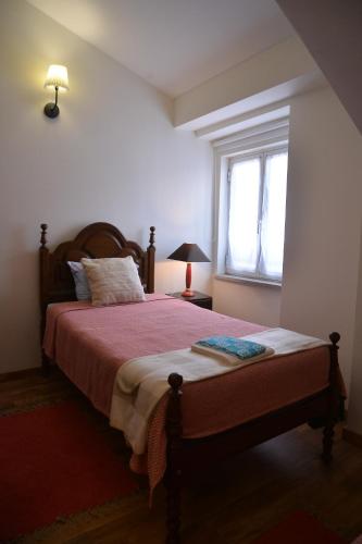 a bedroom with a bed and a window at Casa azul in Gouveia