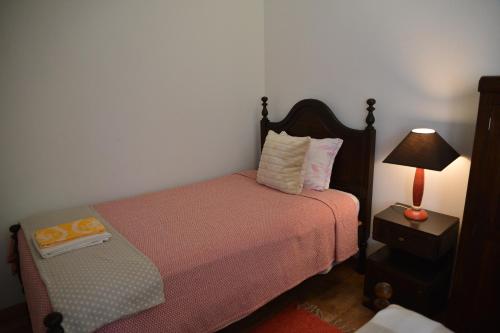 a bedroom with a bed and a lamp on a table at Casa azul in Gouveia