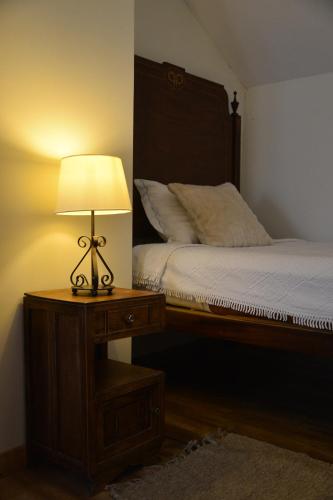 a bedroom with a bed and a lamp on a table at Casa azul in Gouveia