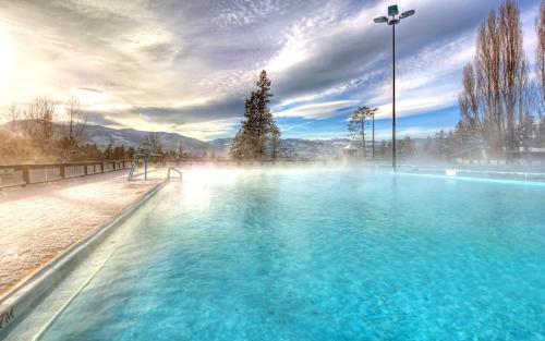 a large swimming pool with blue water in the middle at Fairmont Hot Springs Resort in Fairmont Hot Springs