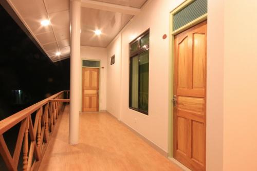 a hallway with a wooden door and a balcony at Shifa Lodge Maldives in Feridhoo