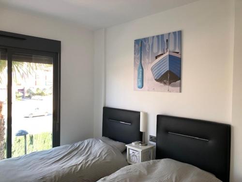 a bedroom with a bed and a picture on the wall at Penthouse 86 LA ZENIA boulevard in Orihuela
