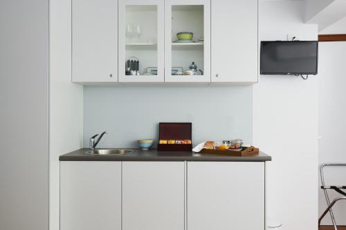 a kitchen with white cabinets and a sink at Mountain Sojourn - Tranquil Kurrajong Getaway in Kurrajong