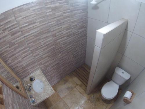 a small bathroom with a toilet and a sink at Os Navegantes B in Guajiru