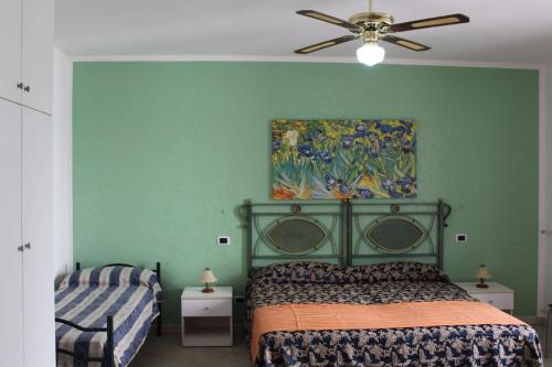 una camera da letto con un letto e un dipinto sul muro di Casa Vacanza Alba 8-10 posti letto a Racale