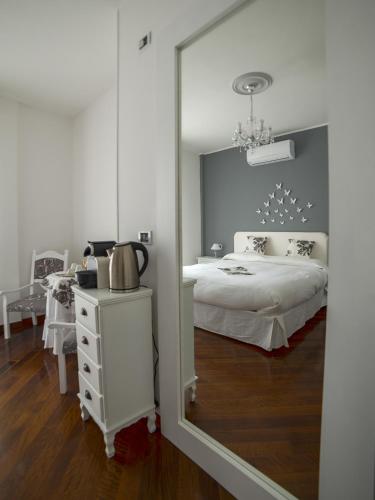 a bedroom with a white bed and a mirror at Agrilea in Santo Stefano al Mare