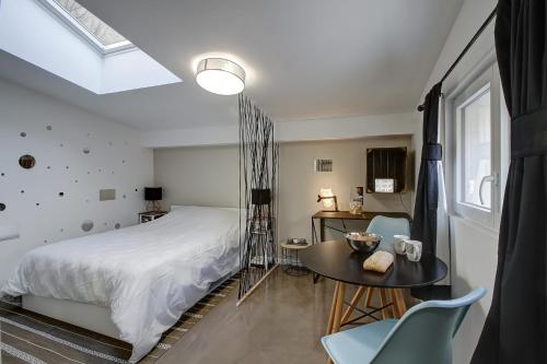 una camera da letto con un letto, un tavolo e delle sedie di STUDIO LE CHOUETTE a Digione