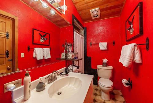 a red bathroom with a sink and a toilet at Dreamcatcher B&B in Taos