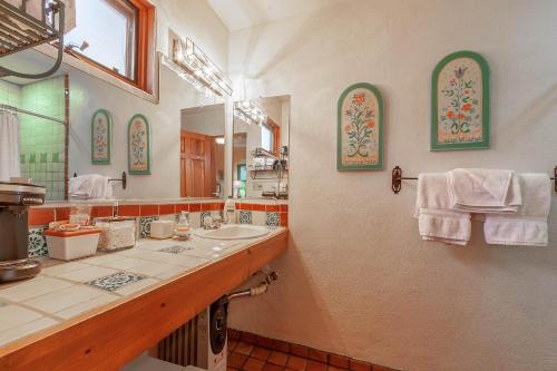 baño con 2 lavabos y espejo grande en Dreamcatcher B&B, en Taos