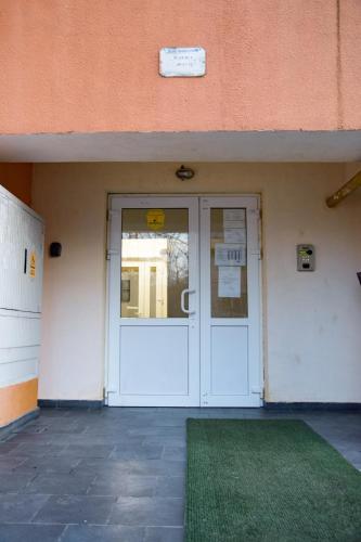 a door to a building with a green rug in front at Happy Blue Apartament in Galaţi