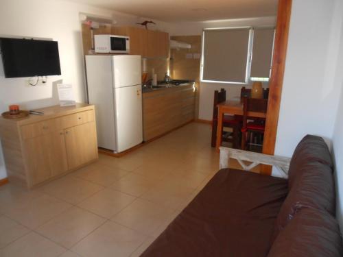 ein Wohnzimmer mit einem weißen Kühlschrank und einer Küche in der Unterkunft Las Agustinas DAT in San Carlos de Bariloche