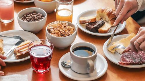 a table with plates of breakfast foods and drinks at Hotel Cusco Plaza Saphi in Cusco