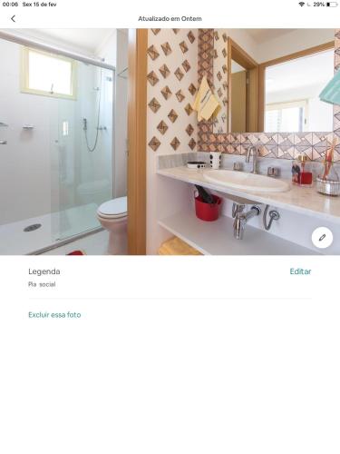 a bathroom with a shower and a sink and a mirror at Amora Três in São Paulo