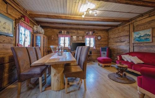 a dining room with a wooden table and a red couch at Grebengradska Medna Hiža in Donje Makojišće