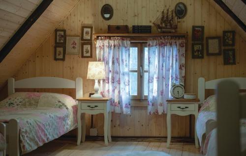 a attic bedroom with two beds and a window at Grebengradska Medna Hiža in Donje Makojišće