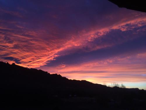 a sunset over a mountain with a red sky at Red Moon Lodge in Moab