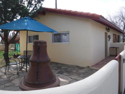 a patio with an umbrella next to a house at Clos Benoit, A Vineyard Inn in El Porvenir