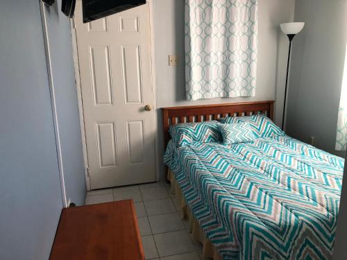 a bedroom with a bed and a door and a table at Brittany Manor Retreat in Kingston