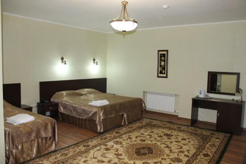 a hotel room with two beds and a mirror at Sultan Beibarys in Astana