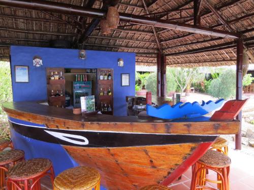 a bar with a wooden boat on the wall at Whale Island Resort in Dam Mon