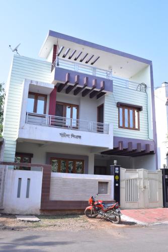 a red motorcycle parked in front of a house at Govind Niwas Home Stay in Gwalior