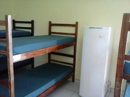 a room with three bunk beds and a refrigerator at CHACARA NOSSA SENHORA DAS DORES in Cachoeira Paulista