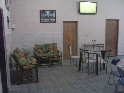 a living room with chairs and a table and a dining room at CHACARA NOSSA SENHORA DAS DORES in Cachoeira Paulista